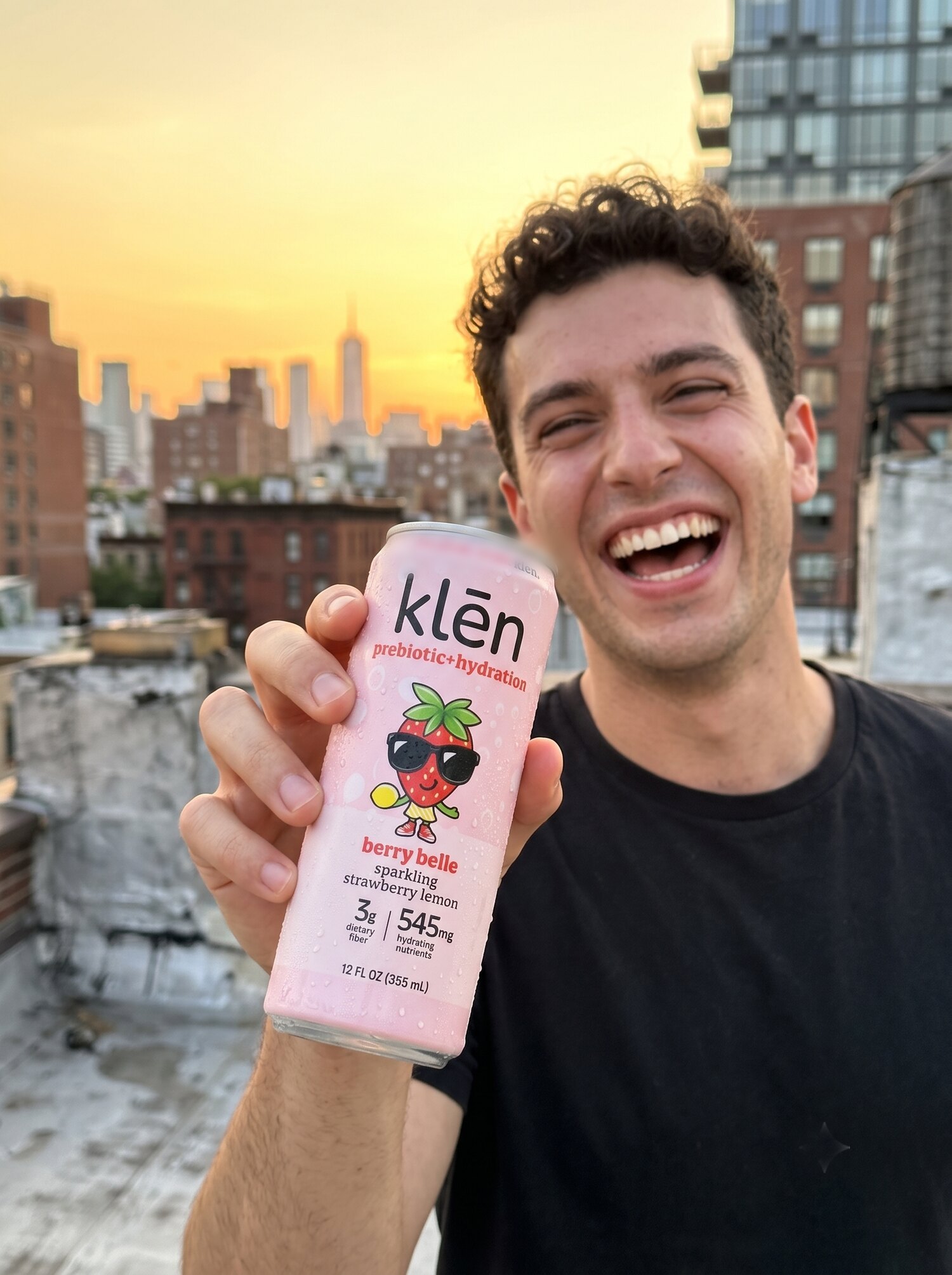 someone holding a klēn berry belle can on a rooftop
